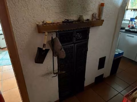 Zwangsversteigerung Einfamilienhaus in Barbing, Sarching – Kachelofen im Erdgeschoss von Haus 12a.