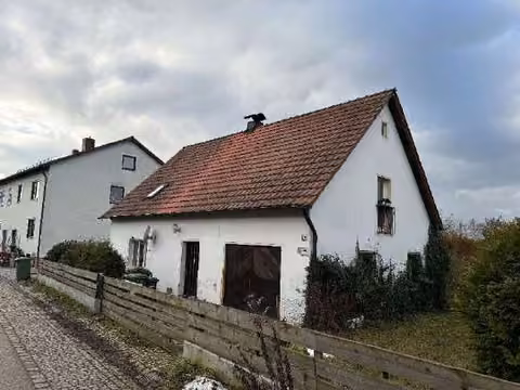 Zwangsversteigerung Einfamilienhaus in Barbing, Sarching – Ostansicht des abbruchreifen Einfamilienhauses 14 an der Straße.