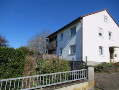 Zwangsversteigerung Einfamilienhaus in Igensdorf, Unterrüsselbach – Südansicht des Wohnhauses mit Balkon und Gartenseite.