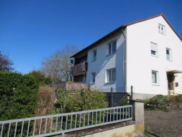 Zwangsversteigerung Einfamilienhaus in Igensdorf, Unterrüsselbach – Südansicht des Wohnhauses mit Balkon und Gartenseite.