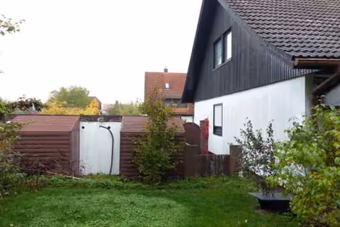 Zwangsversteigerung Einfamilienhaus in Langenzenn – Rückansicht der Garagen und westliche Giebelseite des Wohnhauses.