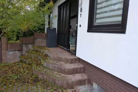 Zwangsversteigerung Einfamilienhaus in Langenzenn – Hauseingangsbereich mit dreistufigem Treppensockel.