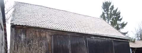 Zwangsversteigerung Einfamilienhaus in Geroda, Platz – Südostansicht des Scheunengebäudes mit Holztoren.
