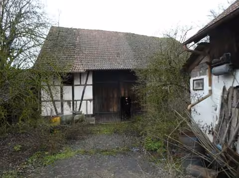 Zwangsversteigerung Einfamilienhaus in Bastheim, Reyersbach – Fachwerkscheune mit Scheunentor vom Innenhof aus gesehen.