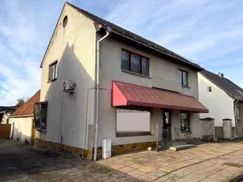 Zwangsversteigerung Gewerbe in Retzow – Straßenansicht des Geschäftshauses mit Fleischereiladen im Erdgeschoss.