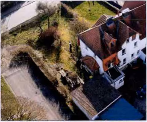 Zwangsversteigerung Doppelhaushälfte in Hessisch Lichtenau – Nordostseitige Gebäudeansicht der Doppelhaushälfte mit Garagen und Gartenteil.