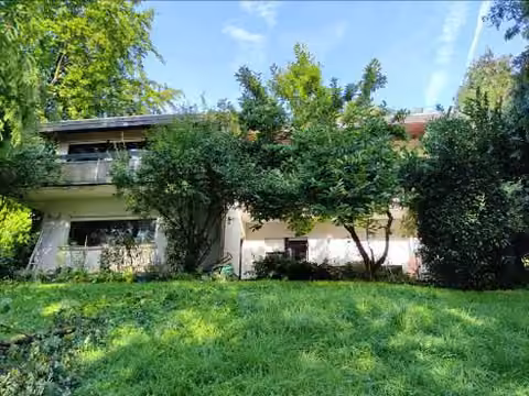 Zwangsversteigerung Einfamilienhaus in Brachttal, Spielberg – Rückansicht des Wohnhauses von Südosten mit Balkonen und Gartenbereich.