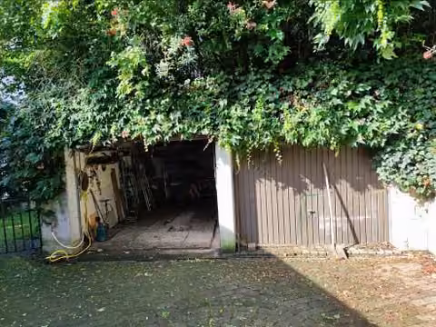 Zwangsversteigerung Einfamilienhaus in Brachttal, Spielberg – Ansicht der freistehenden Doppelgarage mit Begrünung.