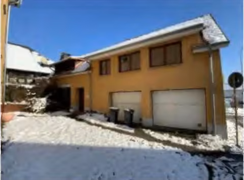 Zwangsversteigerung in Wetzlar, Dutenhofen – Hofansicht des ausgebauten Nebengebäudes mit den beiden Garagentoren.