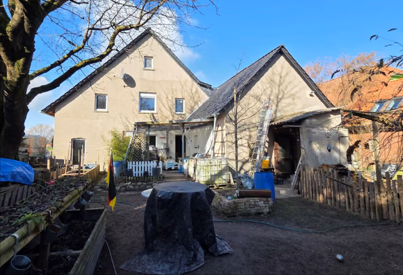 Zwangsversteigerung Einfamilienhaus in Stadthagen – Rückansicht des Wohnhauses und Nebengebäudes mit Gartenbereich.