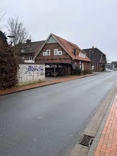 Zwangsversteigerung Einfamilienhaus in Quakenbrück – Straßenansicht Nord-West des Wohnhauses an der Straßenkreuzung.