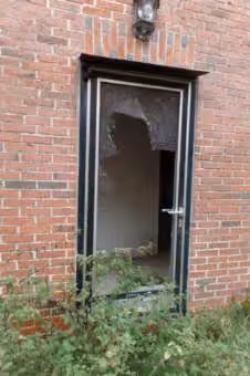 Zwangsversteigerung Einfamilienhaus in Friesoythe, Altenoythe – Hintereingang des Wohnhauses mit beschädigter Verglasung durch Vandalismus.