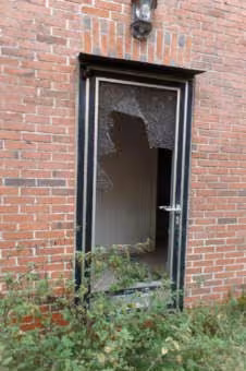 Zwangsversteigerung Einfamilienhaus in Friesoythe, Altenoythe – Hintereingang des Wohnhauses mit beschädigter Verglasung durch Vandalismus.