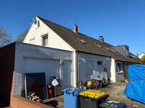 Zwangsversteigerung Reihenhaus in Cloppenburg, Emstekerfeld – Nordöstliche Ansicht des Reihenendhauses mit Garage und Eingangsbereich.