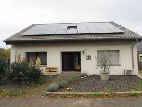 Zwangsversteigerung Einfamilienhaus in Goch, Pfalzdorf – Frontansicht des Hauses mit Hauseingang und Vorgarten.