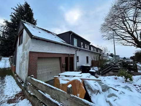 Zwangsversteigerung Reihenhaus in Porta Westfalica, Hausberge – Nordostansicht des Reihenendhauses mit Garage.