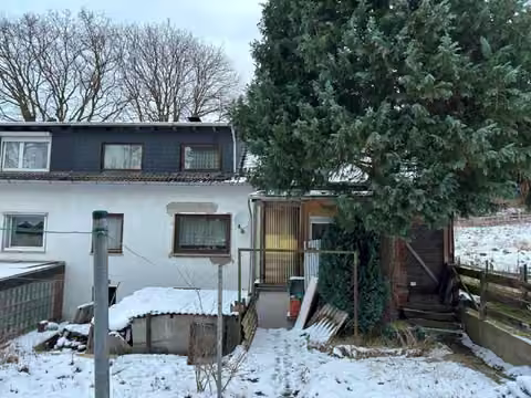 Zwangsversteigerung Reihenhaus in Porta Westfalica, Hausberge – Rückansicht des Gebäudes von der Südseite mit Garten und Anbau.