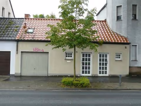 Zwangsversteigerung Mehrfamilienhaus in Hamm, Mitte – Nordansicht des Anbaus Ostenwall 71 mit Garage und Eingang.
