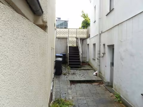Zwangsversteigerung Mehrfamilienhaus in Hamm, Mitte – Außenzugang zur Kellerwohnung 1 an der Gebäudeseite.