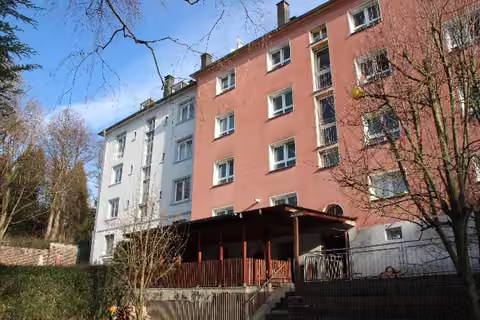 Zwangsversteigerung Mehrfamilienhaus in Wuppertal, Elberfeld – Rückansicht des Gebäudes mit Garten und Terrassenüberdachung.