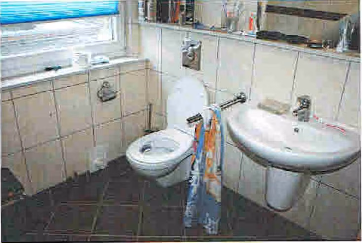 Zwangsversteigerung Doppelhaushälfte in Langenberg – Badezimmer im Dachgeschoss mit WC und Waschtisch.