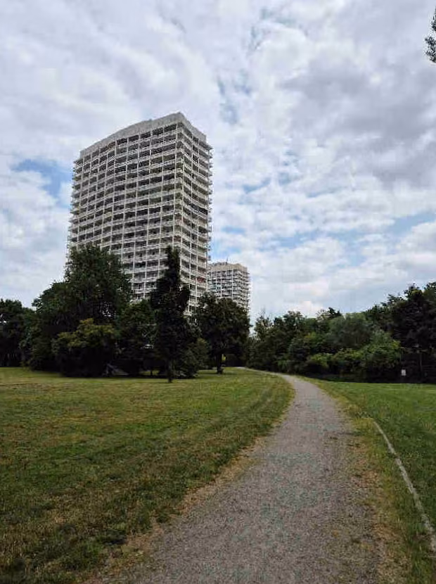 Zwangsversteigerung Eigentumswohnung in Ludwigshafen am Rhein, Friesenheim – Südwestansicht der Wohnanlage mit umliegenden Grün- und Wiesenflächen.