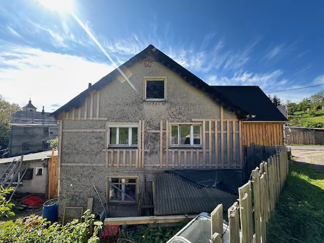 Zwangsversteigerung Einfamilienhaus in Reinsberg, Bieberstein – Giebelseite des Gebäudes mit erkennbaren Fassadenarbeiten.