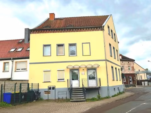 Zwangsversteigerung Mehrfamilienhaus in Schönebeck – Fassadenansicht des Mehrfamilienhauses mit Stellplatzbereich.