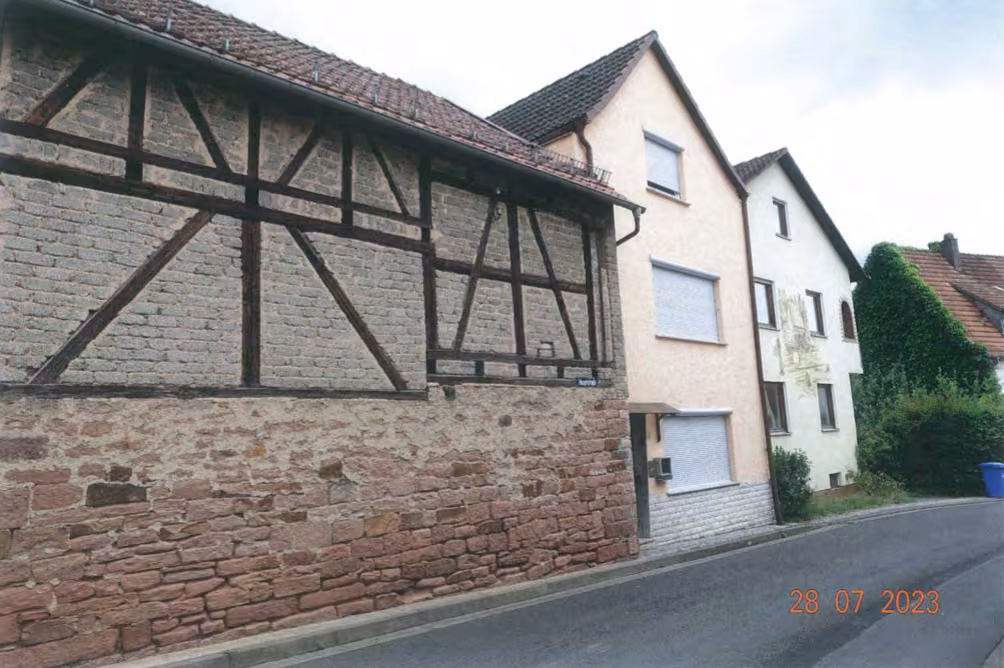 Zwangsversteigerung Einfamilienhaus in Wiesthal – Ansicht der Scheune und des Ensembles von der Straßenseite aus.