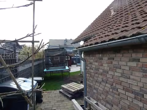 Zwangsversteigerung Zweifamilienhaus in Hamm, Bockum-Hövel – Westliche Gebäudeansicht mit Satteldach und Garagenanbau.