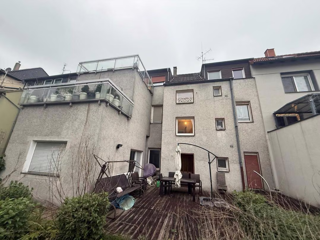 Zwangsversteigerung Mehrfamilienhaus in Essen, Borbeck-Mitte – Rückwärtige Gebäudeansicht mit Anbauten und Terrassen.