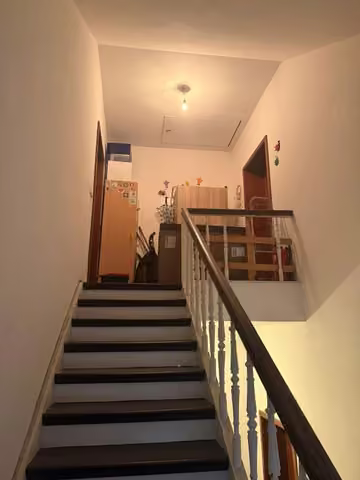 Zwangsversteigerung Mehrfamilienhaus in Essen, Borbeck-Mitte – Treppenhaus mit Holztreppe im Eingangsbereich.
