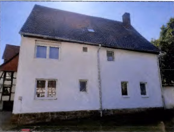 Zwangsversteigerung Zweifamilienhaus in Volkmarsen, Ehringen – Rückwärtige Gebäudeansicht von Westen mit verputzter Fassade.