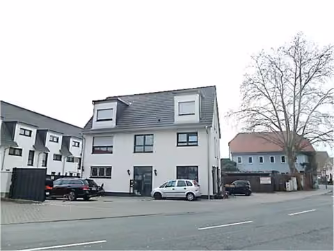 Zwangsversteigerung Einfamilienhaus in Raunheim – Straßenansicht des Objekts mit Gewerbeeingang im Erdgeschoss.