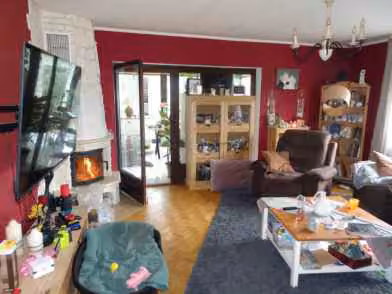 Zwangsversteigerung Einfamilienhaus in Hessisch Lichtenau, Küchen – Wohnzimmer im Erdgeschoss mit Kaminofen und Durchgang zum Wintergarten.