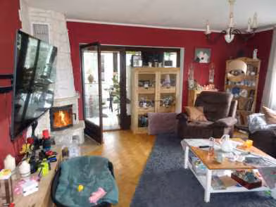 Zwangsversteigerung Einfamilienhaus in Hessisch Lichtenau, Küchen – Wohnzimmer im Erdgeschoss mit Kaminofen und Durchgang zum Wintergarten.