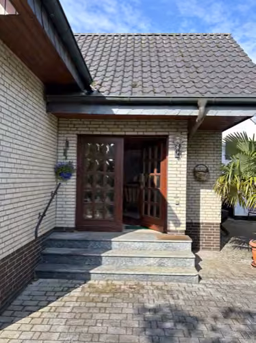 Zwangsversteigerung Einfamilienhaus in Bad Essen, Eielstädt – Überdachter Hauseingangsbereich mit Treppe.