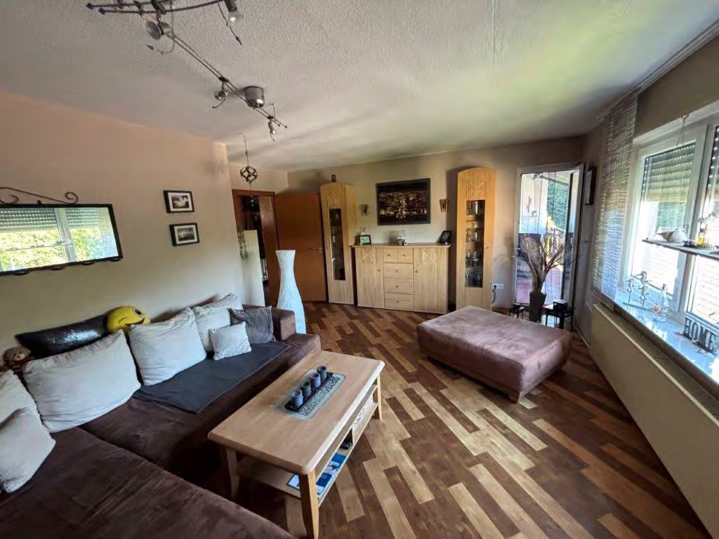 Zwangsversteigerung Einfamilienhaus in Altena, Dahle – Wohnzimmer im Erdgeschoss mit großen Fenstern.
