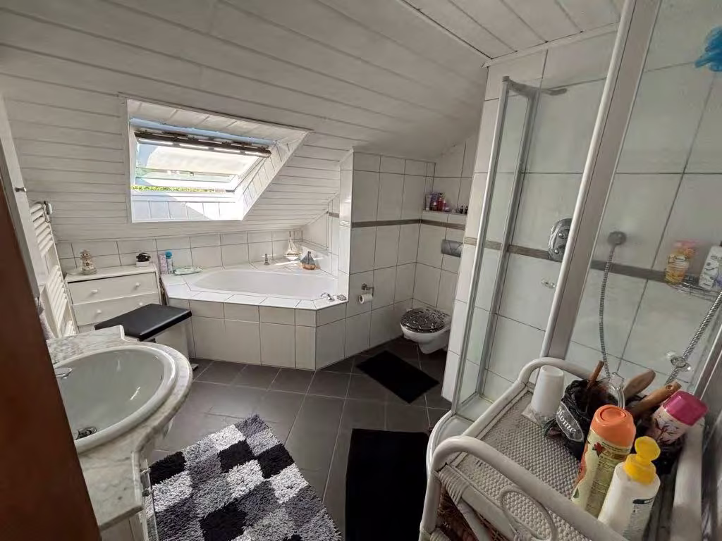 Zwangsversteigerung Einfamilienhaus in Altena, Dahle – Modernisiertes Badezimmer im ausgebauten Dachgeschoss mit Wanne und Dusche.