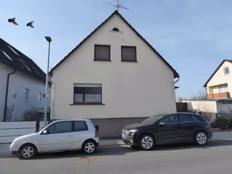 Zwangsversteigerung Einfamilienhaus in Mömbris, Daxberg – Straßenansicht der Giebelseite des Wohnhauses mit Vorgartenbereich und Nachbarbebauung.