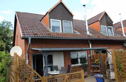 Zwangsversteigerung Eigentumswohnung in Jesendorf – Rückseitige Südansicht des Reihenendhauses mit Terrasse und Gauben.