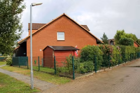Zwangsversteigerung Eigentumswohnung in Jesendorf – Östliche Giebelansicht des Reihenendhauses mit Gartenbereich.