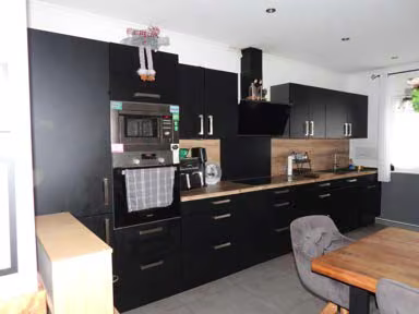 Zwangsversteigerung Einfamilienhaus in Frankenfeld, Bosse – Moderne Einbauküche mit Elektrogeräten und offenem Übergang zum Wohnbereich.