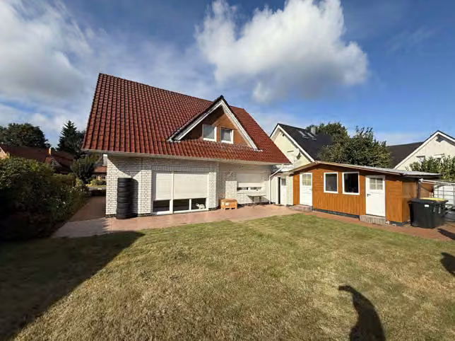 Zwangsversteigerung Zweifamilienhaus in Fürstenau – Rückansicht des Gebäudes mit Garten und Nebengebäude.