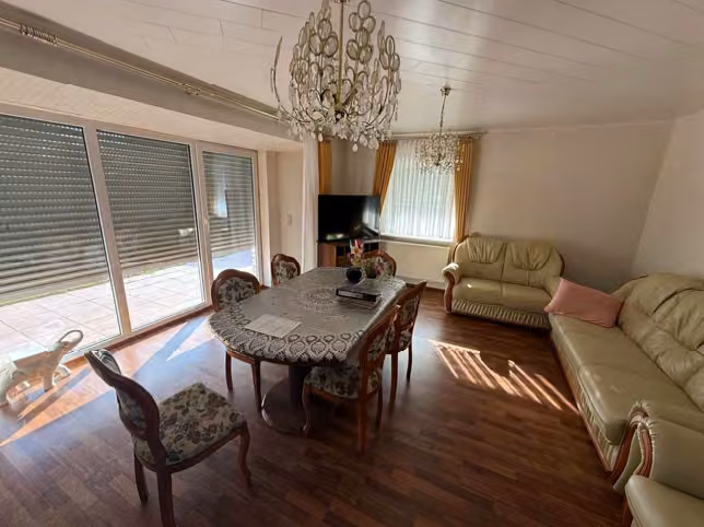 Zwangsversteigerung Zweifamilienhaus in Fürstenau – Wohnzimmer im Erdgeschoss mit Zugang zur Terrasse.