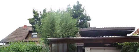 Zwangsversteigerung Eigentumswohnung in Lichtenfels, Trieb – Süd-Ansicht des Wohngebäudes mit Hofbereich und Carport.