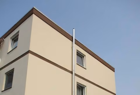 Zwangsversteigerung Eigentumswohnung in Nienburg/Weser – Südansicht des Mehrfamilienhauses mit rot markierter Erdgeschosswohnung und Balkon.