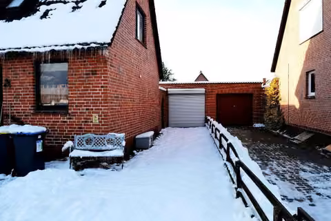 Zwangsversteigerung Einfamilienhaus in Lauenburg/Elbe – Westansicht des Gebäudes mit Anbau.