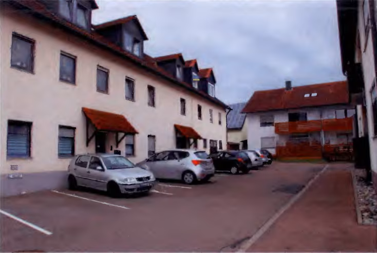 Zwangsversteigerung Eigentumswohnung in Dillingen an der Donau, Hausen – Ostseite des Wohnhauses Untere Hauptstraße 1 mit Stellplätzen.