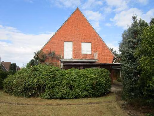 Zwangsversteigerung Einfamilienhaus in Lingen (Ems), Darme – Rückansicht des Gebäudes mit Gartenbereich und überdachter Terrasse.